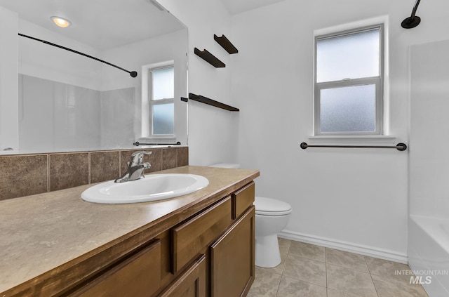 1295 NE Blossom, Mountain Home, ID 83647 - bathroom with toilet, vanity, tile patterned flooring, baseboards, and washtub / shower combination