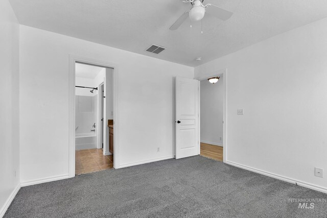 1295 NE Blossom, Mountain Home, ID 83647 - unfurnished bedroom with carpet floors, baseboards, connected bathroom, and tile patterned floors