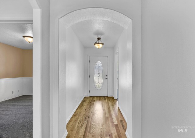 1295 NE Blossom, Mountain Home, ID 83647 - doorway with a textured ceiling, wood finished floors, arched walkways, and baseboards