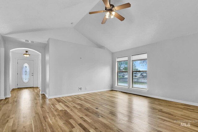 1295 NE Blossom, Mountain Home, ID 83647 - unfurnished living room with plenty of natural light, arched walkways, ceiling fan, vaulted ceiling, and light wood-type flooring