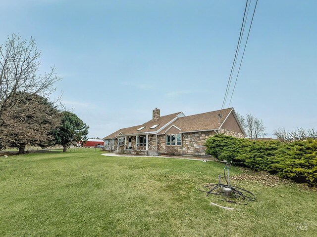 7985 S Cloverdale Rd, Boise, ID 83709 - rear view of property with a lawn, stone siding, and a chimney