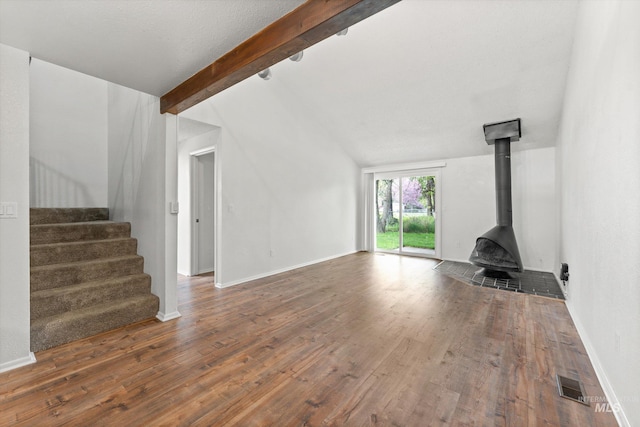 unfurnished living room featuring stairway, baseboards, and wood finished floors