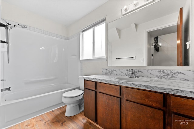 bathroom featuring vanity,  shower combination, wood finished floors, and toilet