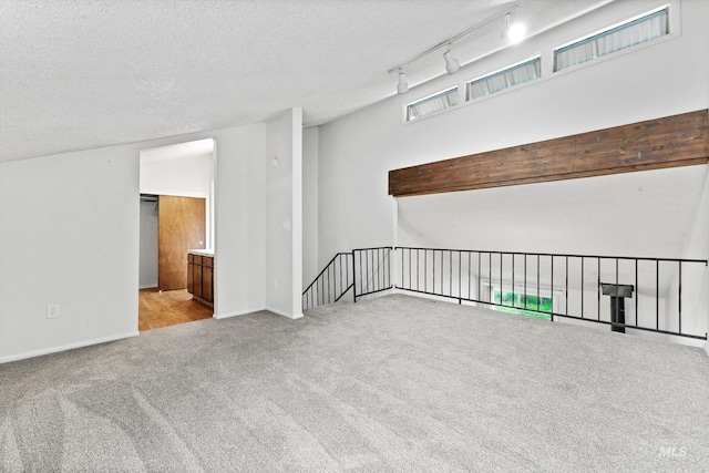 empty room with baseboards, carpet, and a textured ceiling