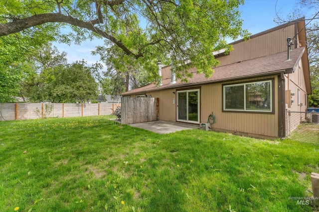 back of property with fence, a chimney, a yard, and cooling unit