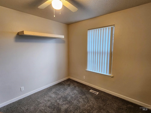 carpeted spare room featuring ceiling fan and a textured ceiling