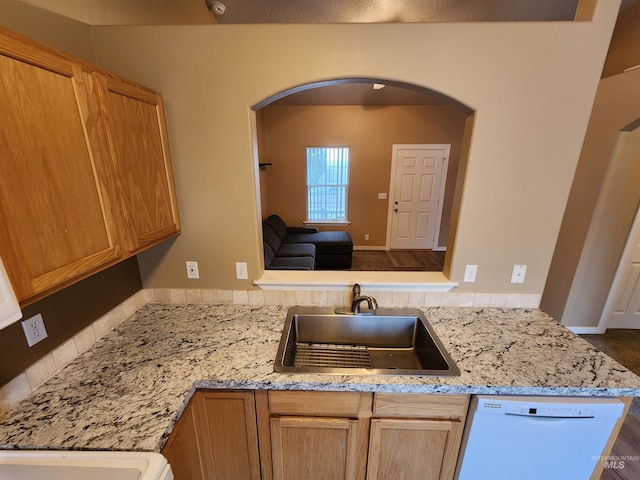 kitchen featuring kitchen peninsula, light brown cabinetry, light stone countertops, sink, and dishwasher