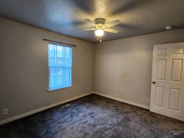 empty room featuring dark colored carpet, a textured ceiling, and ceiling fan