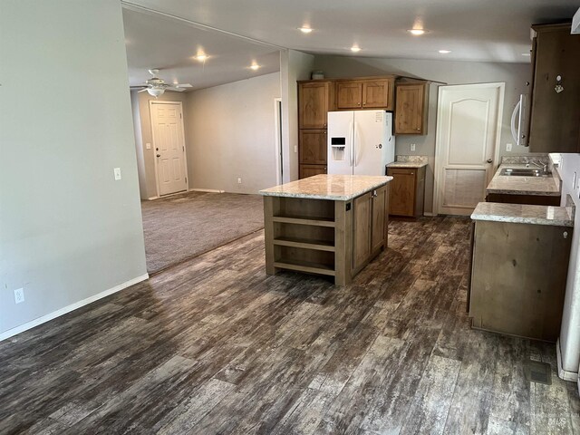 kitchen featuring open shelves, a ceiling fan, white appliances, a center island, and a sink