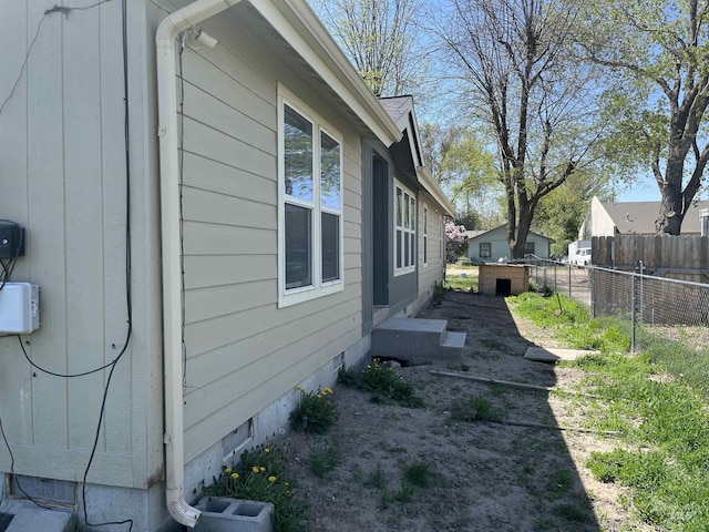 view of side of property with fence and crawl space
