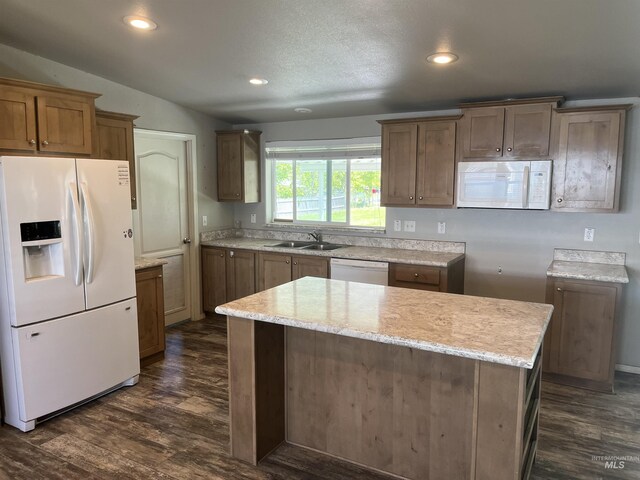 kitchen with light stone counters, a sink, white appliances, recessed lighting, and dark wood-style floors
