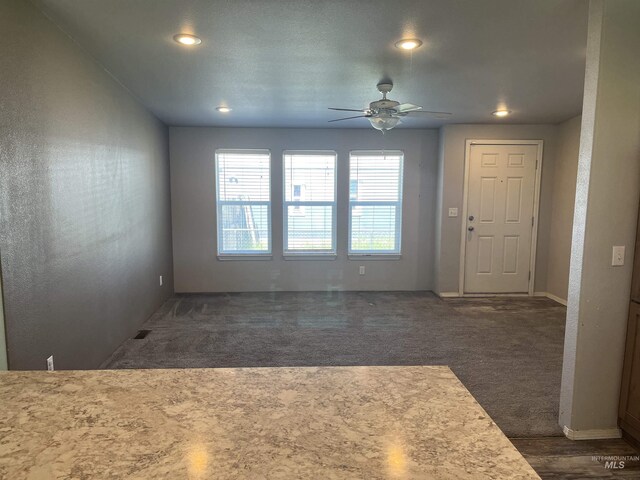 interior space featuring a ceiling fan, recessed lighting, visible vents, and dark colored carpet