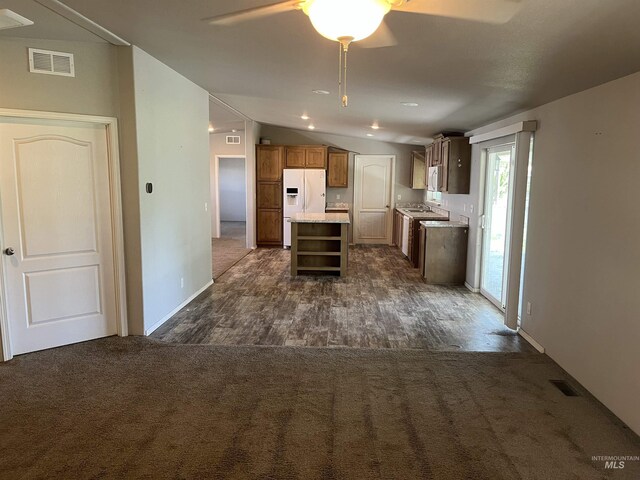 kitchen featuring white fridge with ice dispenser, open shelves, a ceiling fan, and visible vents