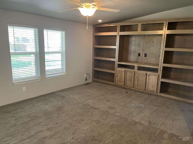 unfurnished living room featuring a ceiling fan, a healthy amount of sunlight, and light carpet