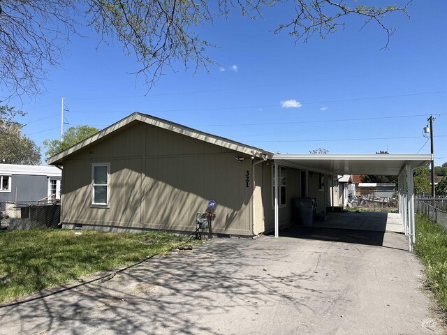 exterior space with fence, driveway, and a carport