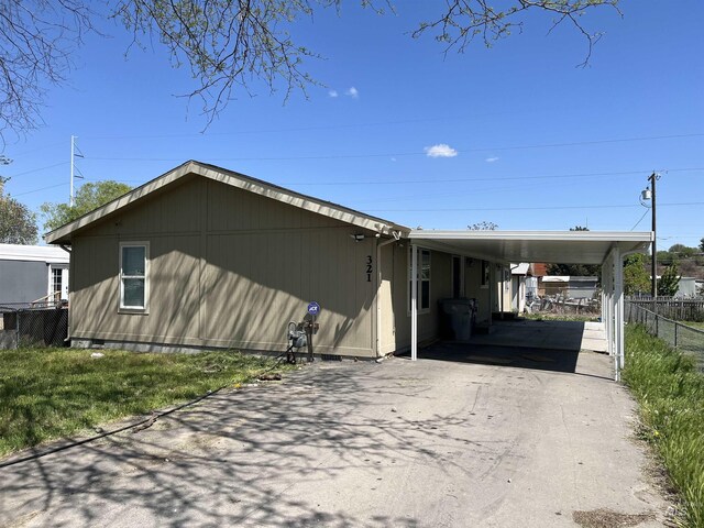 exterior space featuring fence, a carport, and aphalt driveway