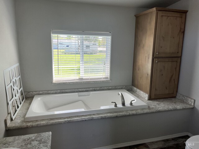 bathroom with toilet and a bath
