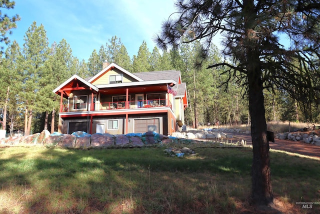 back of property with a balcony and a yard