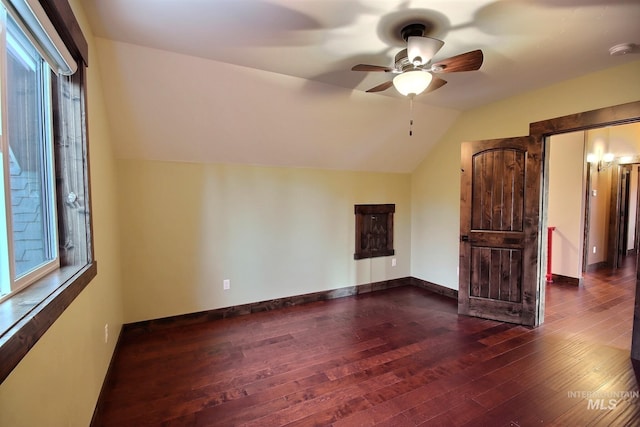 interior space with ceiling fan, dark hardwood / wood-style floors, and lofted ceiling