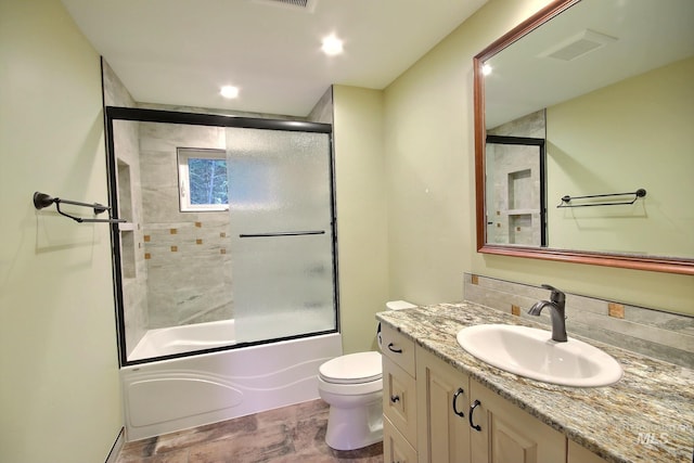 full bathroom with decorative backsplash, vanity, combined bath / shower with glass door, and toilet