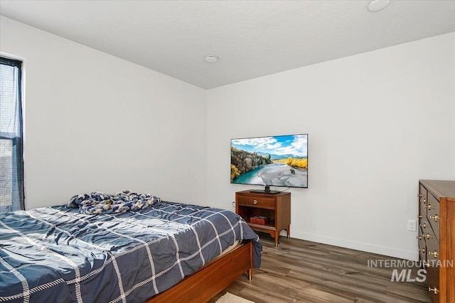 bedroom featuring wood finished floors and baseboards