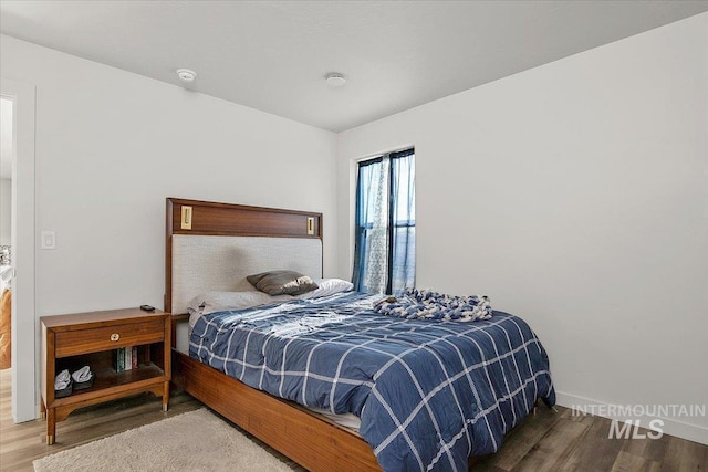 bedroom featuring wood finished floors and baseboards