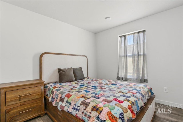bedroom featuring wood finished floors and baseboards