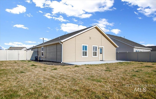 back of property with a gate, a patio, and central AC