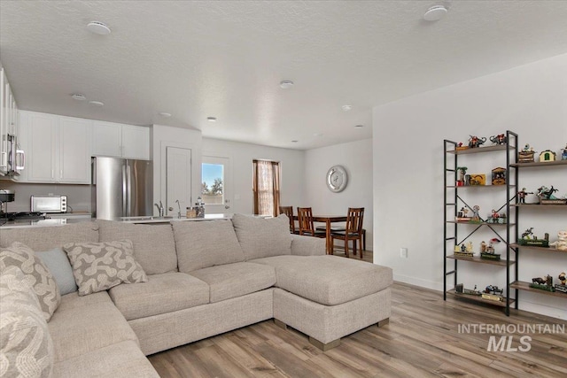 living area with light wood finished floors and baseboards