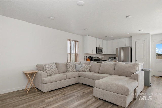 living room with light wood-style floors and baseboards