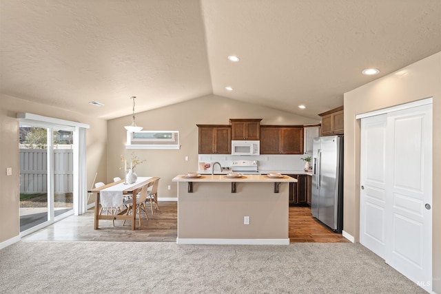 6296 W Mattawa Dr, Meridian, ID 83646 - kitchen featuring light carpet, light countertops, white appliances, and a breakfast bar