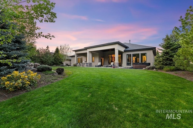 421 E Fishing Creek Ln, Eagle, ID 83616 - back of property at dusk with a hot tub, stucco siding, and a yard