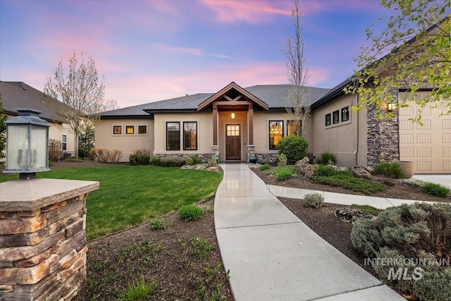 421 E Fishing Creek Ln, Eagle, ID 83616 - view of front of house featuring stucco siding, a lawn, stone siding, and an attached garage
