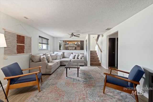 13343 N Horseshoe Bend Rd, Boise, ID 83714 - living area with wood finished floors, a textured ceiling, baseboards, stairway, and a ceiling fan