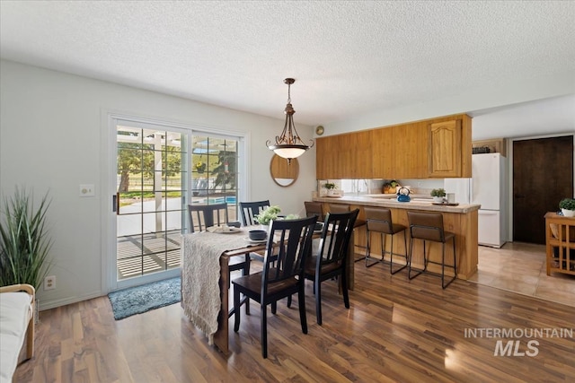 13343 N Horseshoe Bend Rd, Boise, ID 83714 - dining room with light wood finished floors, a textured ceiling, and baseboards