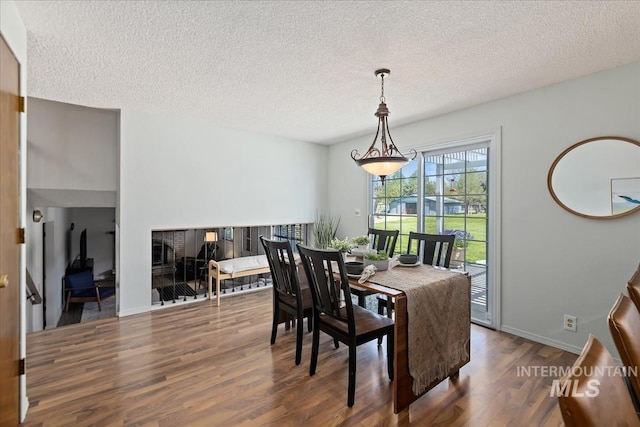 13343 N Horseshoe Bend Rd, Boise, ID 83714 - dining area with wood finished floors, a textured ceiling, and baseboards