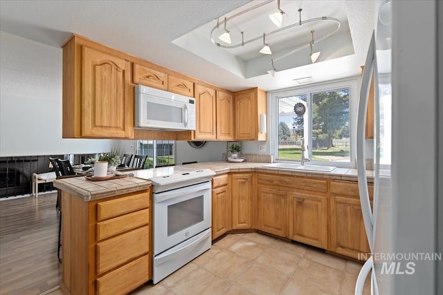 13343 N Horseshoe Bend Rd, Boise, ID 83714 - kitchen with white appliances, a raised ceiling, tile countertops, a sink, and light tile patterned floors