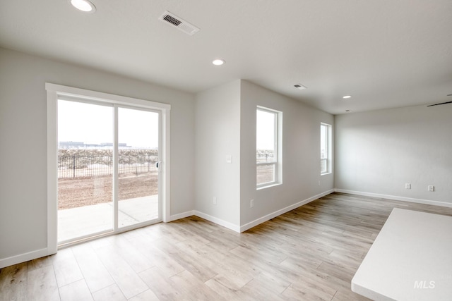 empty room featuring visible vents, recessed lighting, light wood-type flooring, and baseboards