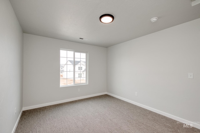 carpeted empty room with baseboards