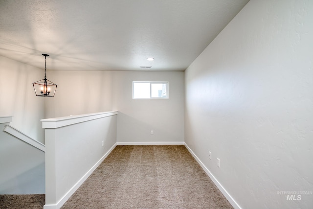 carpeted empty room featuring visible vents, baseboards, and a textured ceiling