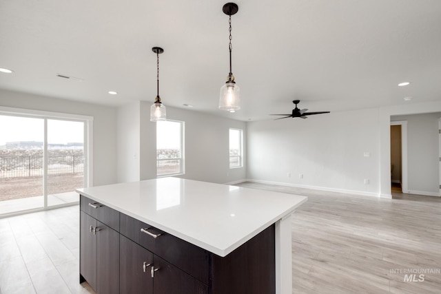 kitchen with a ceiling fan, a healthy amount of sunlight, a center island, and light countertops