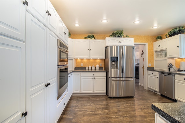 kitchen featuring stainless steel appliances, dark countertops, and dark wood-style flooring