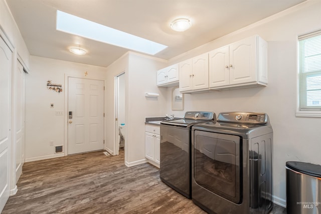 washroom with dark wood-style flooring, cabinet space, a sink, independent washer and dryer, and baseboards