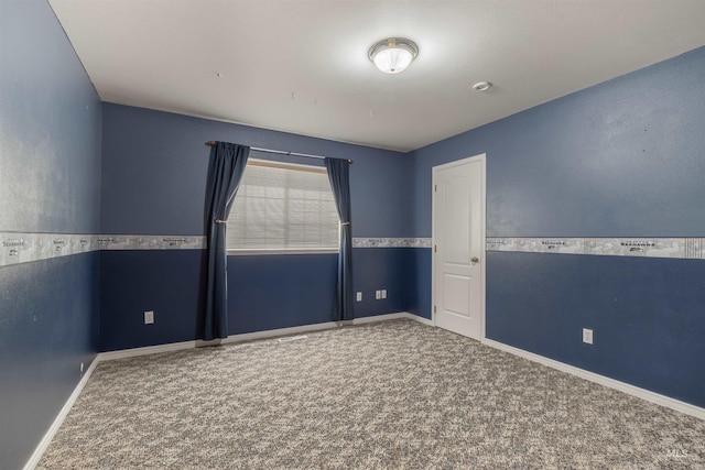 unfurnished room with carpet and baseboards