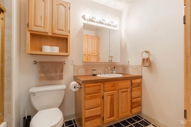 bathroom with vanity, backsplash, toilet, and baseboards