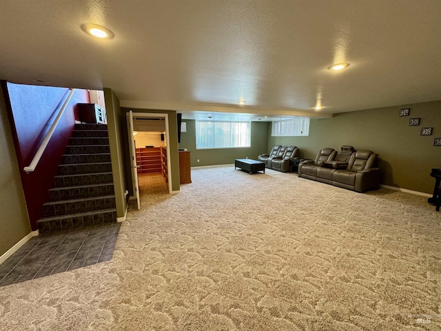 living room featuring carpet floors, baseboards, stairway, and a textured ceiling