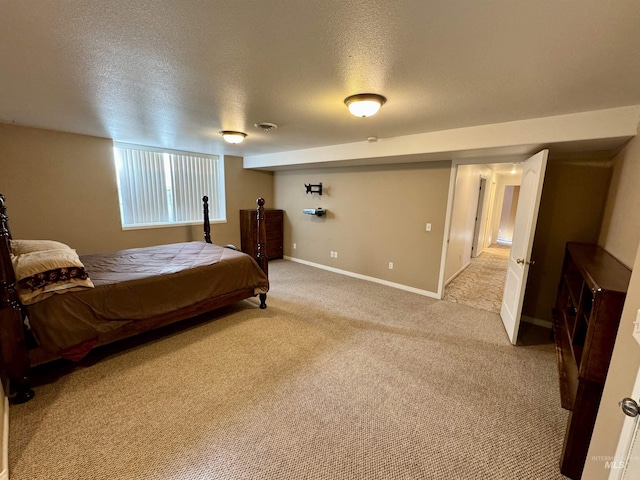 bedroom with light carpet, baseboards, and a textured ceiling