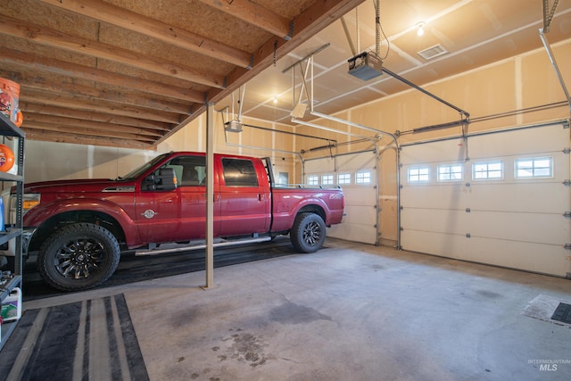 garage featuring a garage door opener and visible vents