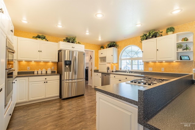 kitchen featuring dark wood-style floors, stainless steel appliances, dark countertops, and white cabinets