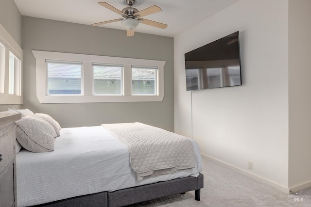 carpeted bedroom featuring baseboards and ceiling fan